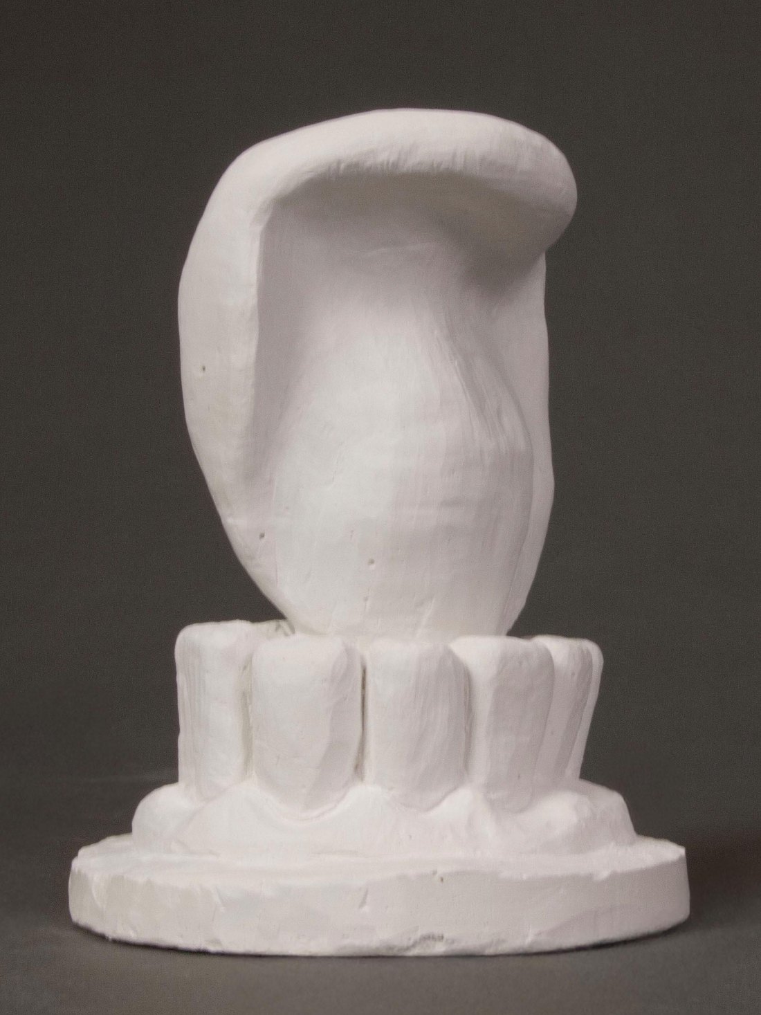 Gnaw: a white sculpture of a curled form rising from a row of teeth.